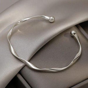 Tvinnat silverarmband med öppet lock – Minimalistisk manschett i 925 sterlingsilver för kvinnor.