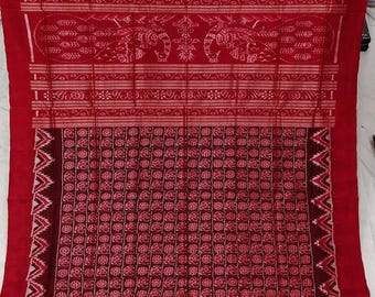 May include: A red and dark maroon textile featuring a grid pattern of small floral motifs. The upper section displays horizontal bands with intricate woven designs, including stylized bird figures and geometric lines across the fabric.