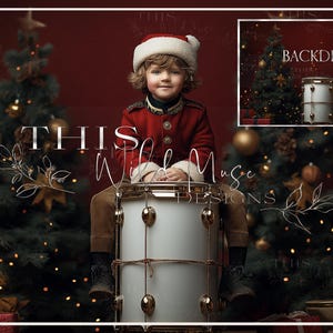 May include: A young boy wearing a red and white Santa suit sits on a white drum with gold accents. He is surrounded by Christmas trees with twinkling lights and red and gold ornaments. The background is a dark red.