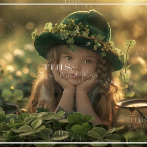 May include: A young girl wearing a green hat with flowers and greenery, sitting in a field of green clover. She is looking at the camera with her hands on her chin.