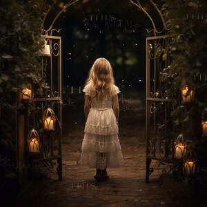 Op de afbeelding: Een jong meisje in een witte jurk staat voor een sierlijke metalen boog die versierd is met brandende kaarsen. De boog is omgeven door weelderig groen en de achtergrond is donker en mysterieus.