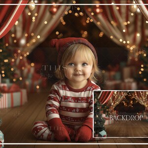 Puede incluir: Un niño pequeño con un pijama a rayas rojas y blancas se sienta frente a un telón de fondo navideño. El telón de fondo presenta una tienda de campaña a rayas rojas y blancas con luces parpadeantes y regalos. El niño sonríe y mira a la cámara.