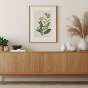 May include: A light wood-tone sideboard with four doors, topped with a framed botanical print, decorative vases, and a small potted plant. A large vase holds dried grasses. The room has a neutral color palette.