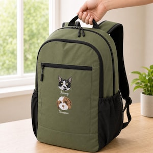 May include: An olive green backpack featuring a black zippered front pocket and side mesh pockets. The front displays an embroidered black and white cat with the name Tommy below it, and a brown and white dog with the name Sammie below it.