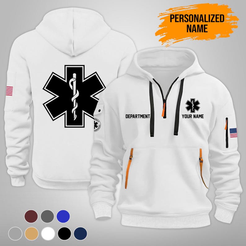 Puede incluir: Sudadera con capucha blanca con un emblema negro y blanco de la Estrella de la Vida en la parte delantera y trasera. Cuenta con cremallera, detalles en naranja y el texto "DEPARTMENT" y "YOUR NAME". Incluye un parche de la bandera estadounidense en la manga. Tambi&eacute;n se ve el texto "PERSONALIZED NAME".