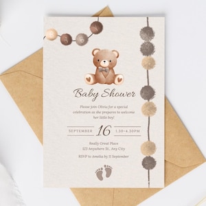 Könnte beinhalten: Eine Babyparty-Einladung mit einem Aquarell-Teddybären und dekorativen Elementen. Die Einladung enthält den Text "Baby Shower", Datum, Uhrzeit und RSVP-Informationen. Die Einladung befindet sich auf einem strukturierten Hintergrund und liegt auf einem braunen Umschlag.