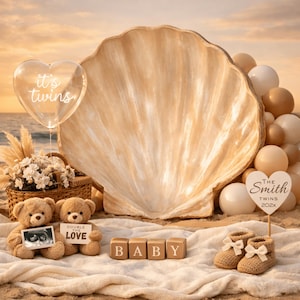 Könnte beinhalten: Ein Baby-Ankündigungs-Setup am Strand. Mit einem großen Muschel-Hintergrund, Teddybären, die ein Ultraschallbild und ein Schild mit der Aufschrift "Double the Love" halten, Holzblöcken mit der Aufschrift "BABY" und einem herzförmigen Ballon mit der Aufschrift "it's twins".