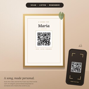 Op de afbeelding: Een goud ingelijste print met de tekst A SONG FOR Maria, een centrale QR-code en de woorden SCAN LISTEN REMEMBER. Een zwarte smartphone toont een bijbehorende QR-code met de tekst NOW PLAYING. Onderaan staat de tekst A song, made personal.