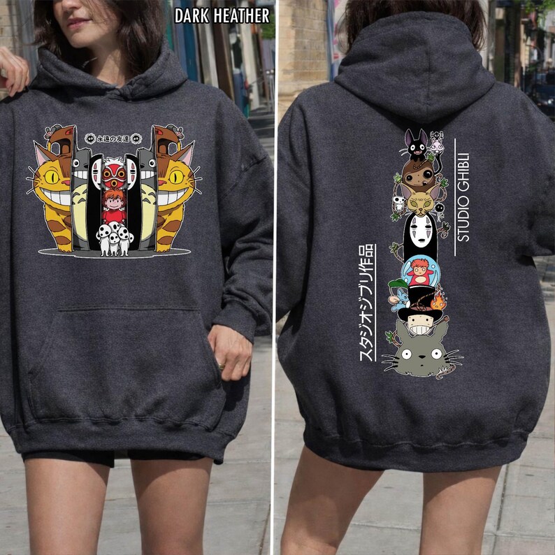 May include: Dark heather gray hoodie featuring Studio Ghibli characters. The front displays a colorful graphic with smiling cat-like creatures and other characters. The back has a vertical stack of characters with "STUDIO GHIBLI" text.