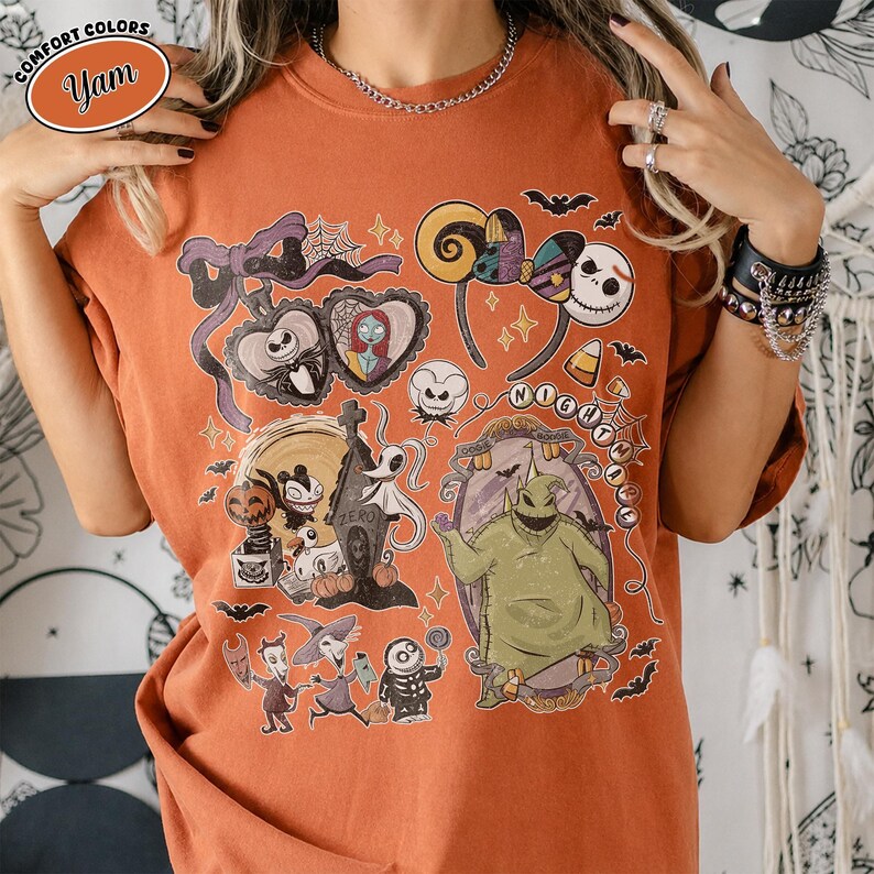 Puede incluir: Una camiseta de cuello redondo color naranja quemado con un estampado gr&aacute;fico de personajes de Pesadilla antes de Navidad, incluyendo a Jack Skellington, Sally, Zero y Oogie Boogie, junto con telara&ntilde;as, murci&eacute;lagos e ilustraciones de ma&iacute;z dulce.