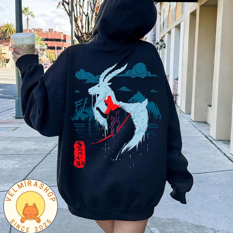 May include: Black hooded sweatshirt with a graphic design on the back featuring a white goat-like creature with red accents, set against a blue and teal landscape. The sweatshirt has a drawstring hood and a front pocket.