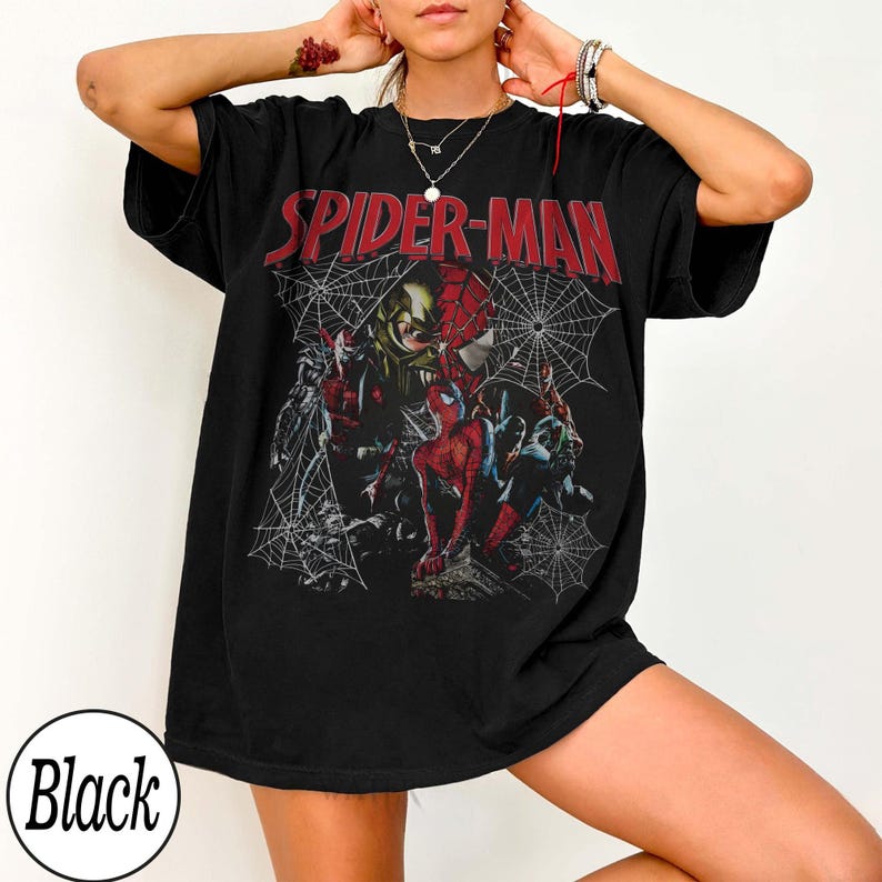 Pu&ograve; includere: T-shirt nero con grafica di Spider-Man e la scritta rossa "SPIDER-MAN". La grafica include vari personaggi di Spider-Man e un disegno a ragnatela. La maglietta &egrave; in stile casual e oversize.