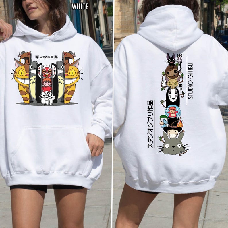 May include: White hoodie featuring a colorful graphic of animated characters on the front and back. The front graphic includes smiling cat-like creatures and other characters. The back graphic features a stack of animated characters with "STUDIO GHIBLI" text.