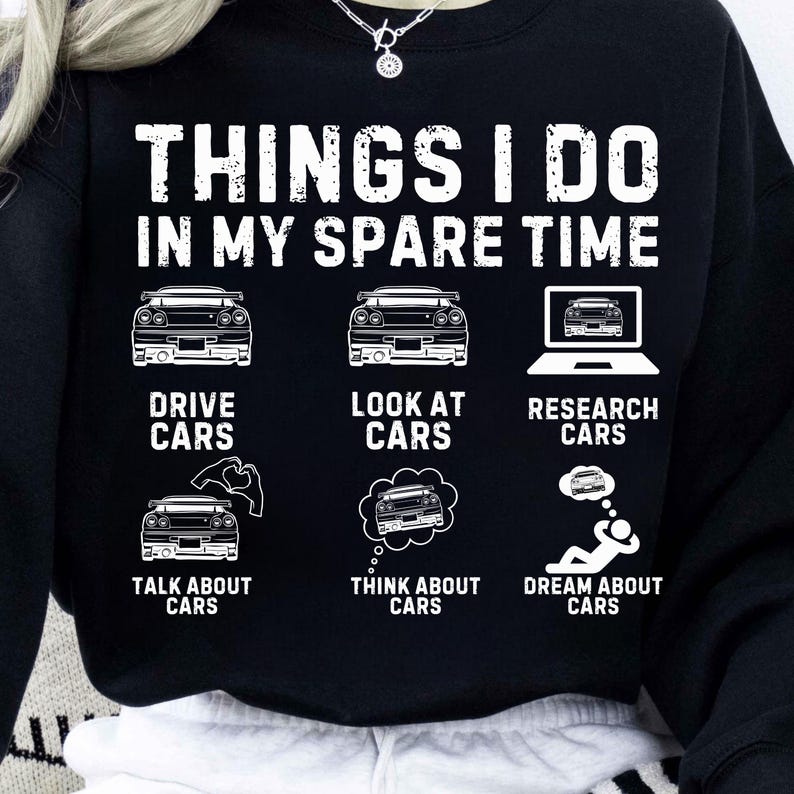 May include: Black sweatshirt featuring white text and car-themed graphics. The text states "THINGS I DO IN MY SPARE TIME" with illustrations of cars and related activities: drive, look at, research, talk about, think about, and dream about cars.