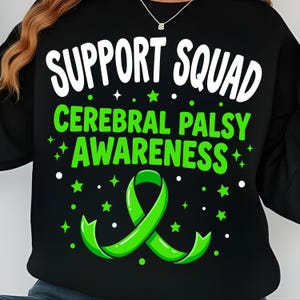 Op de afbeelding: Zwarte sweatshirt met de woorden "SUPPORT SQUAD" in het wit, boven "CEREBRAL PALSY AWARENESS" in het groen. Een groen lint en sterren zijn ook te zien. Het ontwerp is voor Cerebral Palsy bewustwording.