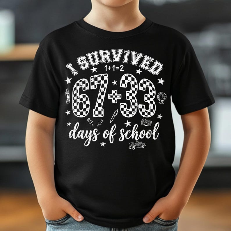 以下が含まれることがあります： 「I Survived 67+33 days of school」の白文字がプリントされた黒いTシャツ。数字は市松模様。鉛筆、クレヨン、地球儀など、学校をテーマにしたグラフィックが描かれています。