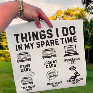 May include: Cream-coloured pillowcase featuring the text "THINGS I DO IN MY SPARE TIME" and car-related illustrations. The pillowcase also includes the phrases "DRIVE CARS", "LOOK AT CARS", "RESEARCH CARS", "TALK ABOUT CARS", "THINK ABOUT CARS", and "DREAM ABOUT CARS".