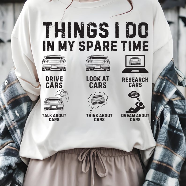 May include: Cream sweatshirt featuring the text "THINGS I DO IN MY SPARE TIME" and car-themed illustrations. The design includes car images, a laptop, and speech bubbles with cars, alongside the phrases "DRIVE CARS", "LOOK AT CARS", "RESEARCH CARS", "TALK ABOUT CARS", "THINK ABOUT CARS", and "DREAM ABOUT CARS".