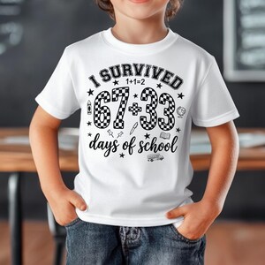以下が含まれることがあります： 「I SURVIVED 1+1=2 67+33 days of school」の黒い文字がプリントされた白いTシャツ。67と33の数字は市松模様。Tシャツはクルーネックで半袖。デザインには星、鉛筆、地球儀、本、スクールバスが含まれています。