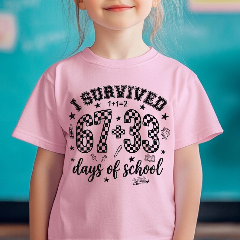 以下が含まれることがあります： 「I SURVIVED 67+33 days of school」の黒い文字がプリントされたピンク色の半袖Tシャツ。星、鉛筆、地球儀、スクールバスのグラフィックが含まれています。