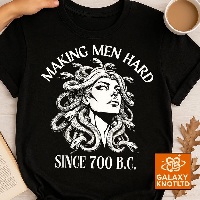 May include: Black t-shirt featuring a Medusa illustration with the text "MAKING MEN HARD SINCE 700 B.C." The graphic is in white and depicts Medusa with snakes for hair. The shirt has a crew neck and short sleeves.