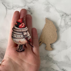 A red bird in clothes, wooden cutout for crafting and jewellery making.