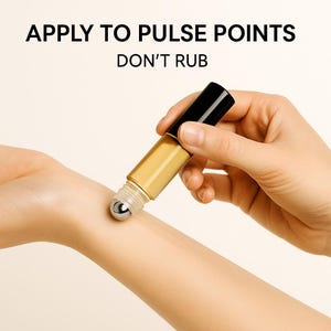 K&ouml;nnte beinhalten: Ein goldfarbener &auml;therischer &Ouml;l-Roller-Applikator mit schwarzer Kappe wird auf das Handgelenk einer Person aufgetragen. Der Text "APPLY TO PULSE POINTS DON'T RUB" steht oben im Bild.