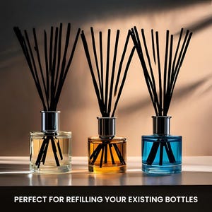 May include: Three glass diffuser bottles with black reeds. The bottles contain yellow, orange, and blue liquids. Each bottle has a silver-coloured collar. The text at the bottom reads "PERFECT FOR REFILLING YOUR EXISTING BOTTLES."