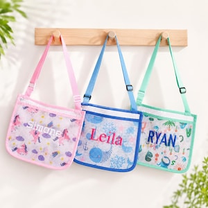 May include: Three rectangular mesh bags with adjustable straps, each featuring a unique pattern and a personalized name embroidered on the front. The pink bag displays unicorns, the blue bag shows sea creatures, and the green bag features cacti.