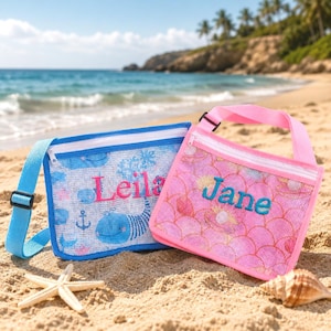 May include: Two rectangular mesh bags with zippers and adjustable straps. The blue bag features a whale pattern and the name Leila in pink embroidery. The pink bag features a mermaid scale pattern and the name Jane in teal embroidery.