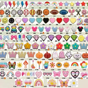 May include: A selection of colourful, embroidered patches in various shapes and designs. Includes stars, lightning bolts, sports balls, hearts, smiley faces, butterflies, crowns, and more. Ideal for decorating clothing or accessories.