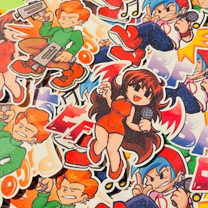 Può includere: Una collezione di adesivi glitterati con personaggi di Friday Night Funkin, tra cui Pico con pistole, Boyfriend con un microfono e Girlfriend con ali rosse. Gli adesivi mostrano colori vivaci, contorni marcati e testo stilizzato.