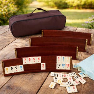 May include: A wooden Rummikub game set with brown racks and tiles. The set includes a brown carrying case and a light blue bag. The tiles are white with colored numbers. The game is displayed on a wooden table.