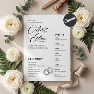 Può includere: Invito di nozze con i nomi Olivia Parker ed Ethan Brooks, Napa Valley, California, 21 settembre 2026. L'invito include i dettagli della cerimonia e dell'evento, circondato da rose bianche e verde.