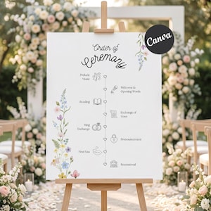 May include: A white sign on a wooden easel displays the "Order of Ceremony" for a wedding. The text is in black script and includes sections for Prelude Music, Reading, Ring Exchange, and First Kiss. Floral accents and a Canva logo are visible.