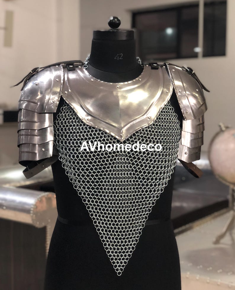 May include: A silver-colored medieval armor set, including a chest plate, shoulder guards, and chainmail. The armor is displayed on a black mannequin. The text "AVhomedeco" is visible on the chainmail.