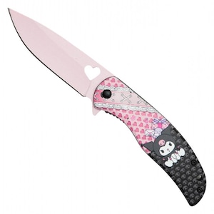 May include: A pink folding knife with a heart-shaped cutout in the blade. The handle features a pink and white pattern with hearts and a cartoon character. The blade is approximately 3 inches long.