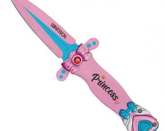 Puede incluir: Una daga de juguete rosa con una hoja y detalles azules. El mango está decorado con un lazo, un corazón y la palabra "Princess". La marca "WARTECH" está impresa en la hoja.