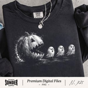 May include: A black crewneck sweatshirt featuring a white graphic print of a large carved jack-o'-lantern pumpkin with a jagged mouth chasing three small ghosts. The garment has a Comfort Colors brand label at the inner neckline and a silver chain.