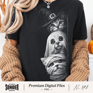 Könnte beinhalten: Schwarzes T-Shirt mit einem Halloween-Motiv von drei Katzen in Kostümen: eine Hexe, ein Geist und eine Mumie. Die Grafik ist monochrom. Der Text "Premium Digital Files" steht darunter.
