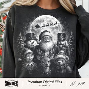 Könnte beinhalten: Ein schwarzes Sweatshirt mit Rundhalsausschnitt und einem monochromen Aufdruck von Weihnachtsmann, Schneemann, Nussknacker, Elf, Rentier und Teddybär. Darüber ist eine große Mondscheibe mit dem Schlitten zu sehen. Text: Studio Sonder Supply.