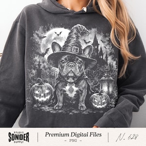 May include: A charcoal gray hooded sweatshirt featuring a graphic print of a French bulldog wearing a witch hat and cape. The scene includes two jack-o'-lanterns, a full moon, flying bats, and a dark castle silhouette in the background.