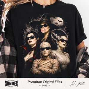Könnte beinhalten: Ein schwarzes T-Shirt mit einem Grafikdruck von vier klassischen Horrorfiguren, die eine Sonnenbrille tragen. Das Design zeigt eine Hexe, die eine Kaugummiblase macht, einen Vampir, eine Mumie mit verschränkten Armen und eine Braut vor Mondschein.