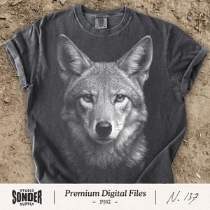 May include: A charcoal grey short-sleeve t-shirt featuring a detailed white graphic illustration of a coyote head centered on the front. The shirt has a crew neckline and a faded, vintage-style wash. The text Studio Sonder Supply Premium Digital Files N. 137 is visible.