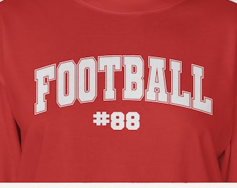May include: A red long-sleeve shirt with the word "FOOTBALL" in white, arched across the chest, with the number "88" below it. The shirt has a crew neck and is made of a soft material.