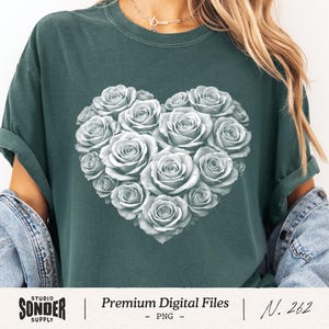 May include: Dark teal t-shirt featuring a heart-shaped design composed of white roses. The shirt has rolled-up sleeves and is part of the Studio Sonder Supply collection. The text "Premium Digital Files" and "N. 262" are also visible.
