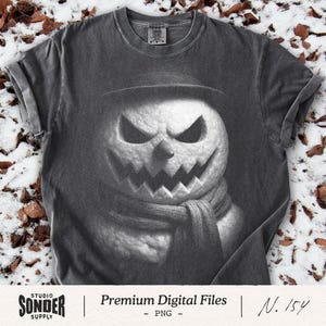 May include: Dark gray t-shirt featuring a detailed illustration of a menacing snowman with a carved pumpkin face, wearing a hat and scarf. The shirt has rolled-up sleeves and a crew neck. The text "Premium Digital Files - PNG" is at the bottom.