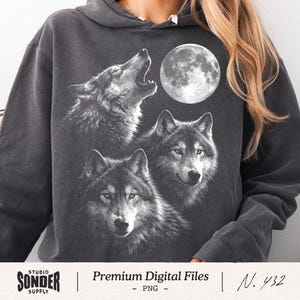 May include: A charcoal gray hooded sweatshirt featuring a white graphic print of three wolves and a full moon. One wolf is howling upward, while the other two are positioned below. The text "STUDIO SONDER SUPPLY | Premium Digital Files - PNG - | N. 432" is printed at the bottom.