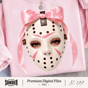 May include: A white hockey mask with pink accents and a pink bow, adorned with rhinestones around the eyes. The mask is set against a pink sweatshirt. The image includes the text "Premium Digital Files - PNG" and "N. 577".