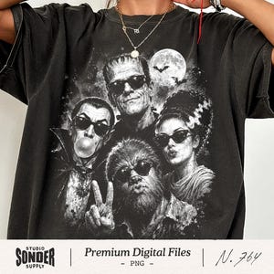May include: A black short-sleeve t-shirt featuring a graphic print of four classic monsters wearing sunglasses. The design includes a vampire blowing a bubble, a creature with a high hairstyle, a werewolf making a peace sign, and a tall figure.